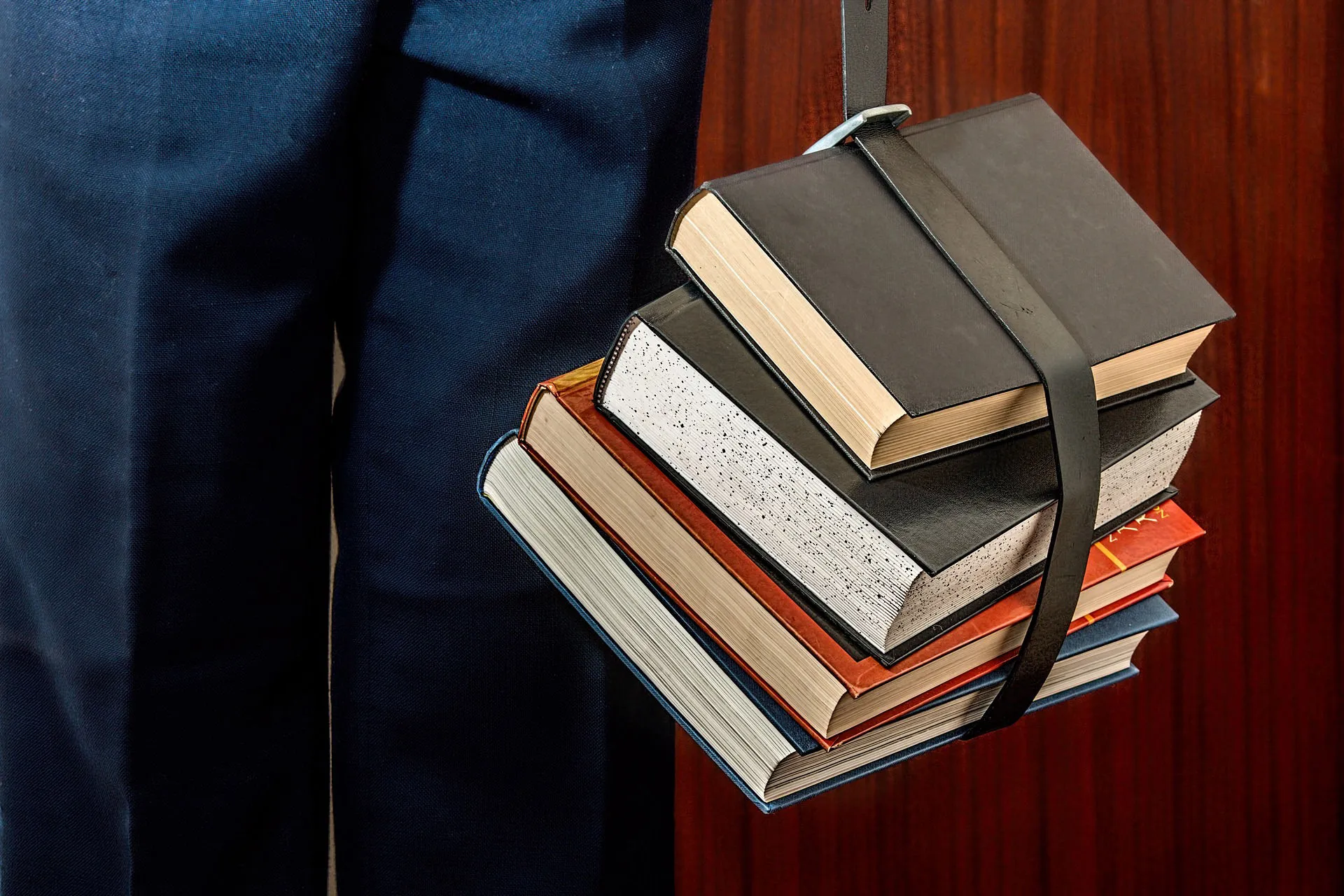 A stack of books held by a strap